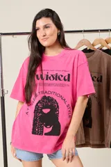 Remera oversize color fucsia con estampa de texto y figura femenina con peinado afro.
