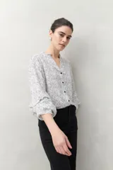 Camisa de manga larga estampada en azul y blanco, confeccionada en viscosa, con cuello mao con pequeño volado y mangas con leve volumen.