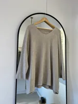 Sweater beige de corte recto con escote en pico y detalle de brillo sublimado.