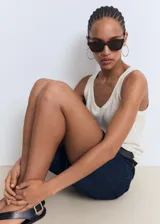 Top sin mangas de lino color blanco roto, con cuello redondo y tirantes anchos, de corte recto.