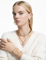 Conjunto de dos anillos Swarovski color dorado con cristales blancos redondos engarzados.