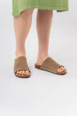 Sandalias planas de cuero color negro, con base anatómica de corcho y capellada ancha.