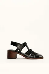 Sandalias plateadas de cuero con tiras entrecruzadas y hebilla lateral. Taco de madera de 6 cm.