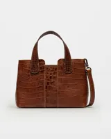 Cartera de mano negra en cuero grabado tipo croco, con asas cortas y correa ajustable.