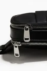 Bolso bandolera negro de cuero sintético con dos compartimentos con cierre, correa ajustable con hebilla y forro interior.
