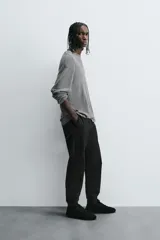 Pantalón jogger negro de corte slim fit, confeccionado en tejido de algodón con cintura elástica ajustable con cordón, bolsillos frontales y traseros de vivo, y bajo con puño elástico.