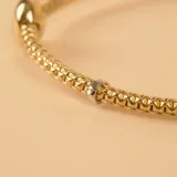 Pulsera de oro amarillo y blanco 18k con esferas y malla extensible.