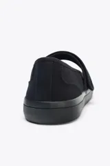 Zapato plano tipo bailarina en tejido color negro. Detalle de pespunte en el cuerpo, tira con adhesivo ajustable, suela engomada y acabado en punta redonda.
