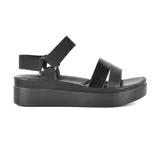 Sandalias negras de plataforma con tiras anchas de charol y ajuste con hebilla en el tobillo.