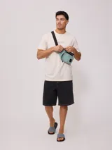 Riñonera negra de nylon arrugado con dos compartimentos con cierre y logo de la marca en relieve.