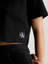 Remera negra corta de punto canalé con cuello tipo chomba y corte holgado.