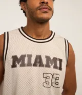 Musculosa deportiva de baloncesto color crema con cuello redondo y ribete en marrón. Estampado frontal con la palabra "Miami" y el número 33 en marrón.
