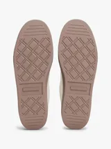 Zapatillas deportivas de corte bajo confeccionadas en piel napa de color beige claro. Presentan un diseño clásico con cordones al tono, un monograma TH texturizado en el lateral y un panel de contraste en el talón de color rosa. La suela es de goma en tono marrón claro.