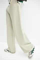 Pantalón de lino color verde claro, de tiro alto con cintura elástica, bolsillos al bies y bolsillos atrás insertados. Piernas rectas con pliegue cosido adelante.