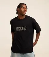Remera negra de corte boxy con estampa frontal de Gasparin psicodélico.