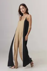 Mono largo de diseño holgado con breteles finos y escote en V. Presenta un diseño tricolor con bloques verticales en beige, negro y blanco.