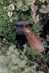 Mocasines marrones de cuero con elásticos laterales y tirador trasero.