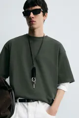 Remera verde oscuro de corte oversize, manga corta y cuello redondo.