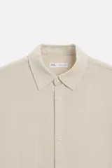 Camisa celeste de corte recto, manga corta y cuello solapa.