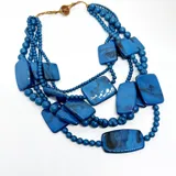 Collar de múltiples hilos con cuentas de resina azul en diferentes formas y tamaños.