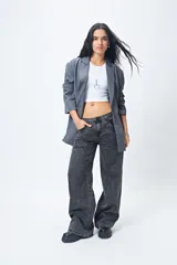 Pantalón de jean gris oscuro, tiro bajo, corte baggy y doble bolsillo.