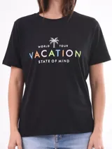 Remera negra de algodón con cuello redondo y mangas cortas. Estampado frontal con la frase "World Tour Vacation State of Mind" en letras de colores y un pequeño dibujo de una palmera.
