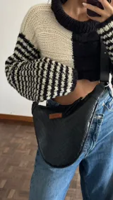 Bandolera negra de cuero con textura croco, correa ajustable y logo de la marca en etiqueta de cuero.