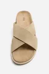 Sandalia plana color beige con dos tiras anchas cruzadas en el empeine, plantilla anatómica y suela de yute.