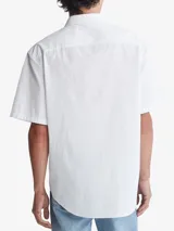 Camisa blanca de manga corta con cierre frontal con botones y bolsillo de pecho.