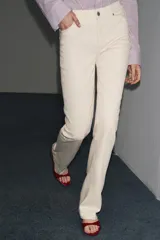 Pantalón de jean azul oscuro, de tiro bajo, corte slim fit y bootcut. Con cinco bolsillos y cierre frontal con cremallera y botón.