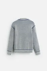 Jersey de punto con cuello redondo y manga larga. Diseño a rayas verticales en color azul marino y blanco.