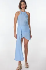 Vestido corto azul celeste con cuello halter fruncido y detalle de drapeado asimétrico con lazo lateral que cae en una cola corta.