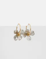 Aros argolla dorados con dije de flor plateada y centro dorado.