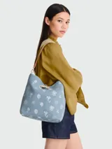 Bolso tipo cubo Longchamp modelo Le Roseau Denim, color gris oscuro con estampado de flores blancas. Tiene asa corta de cuero marrón y cierre con botón a presión. Incluye correa larga extraíble y ajustable.