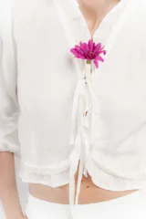 Blusa color blanco de lino, con mangas 3/4 y volados en el frente. Se ata con lazos en el centro.