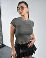 Remera gris de tejido de punto acanalado, con cuello redondo, mangas cortas con detalle desflecado y bajo con roturas.