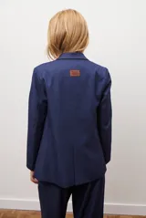 Blazer azul de jean textil, con solapa clásica, un botón frontal y bolsillos laterales.