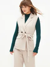 Chaleco negro con solapas cruzadas, doble botonadura, bolsillos laterales y lazo para atar en la cintura.