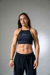 Top deportivo negro con estampado de líneas horizontales y logo de la marca en blanco.