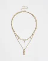 Collar dorado de múltiples cadenas con dije de zapatillas de ballet y strass rosados.