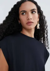 Blusa color crema de tejido acanalado, con cuello redondo y mangas cortas con hombreras.