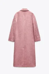 Abrigo amplio color rosa, confeccionado en hilatura con lana y alpaca. Tiene cuello solapa, manga larga, forro interior y cierre frontal con gancho metálico.