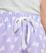 Short de pijama femenino estilo runner, color lila con estampado de corazones blancos, cintura elástica y lazo de ajuste blanco.