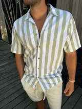 Camisa de manga corta con rayas verticales verdes y blancas, cuello clásico y cierre con botones.