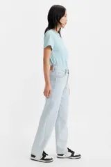 Pantalón jean celeste de corte ancho, con tiro medio, cierre con botones y aberturas en el ruedo.