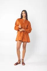 Vestido corto azul con escote con cordones, mangas largas abullonadas y corte evasé.
