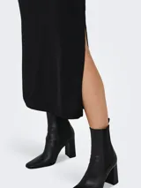 Vestido midi negro de corte camisole con breteles finos y abertura en la pierna.