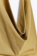 Top color ocre de algodón con cuello halter fluido, espalda descubierta y efecto lavado.