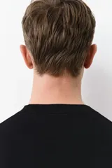 Remera negra de punto fino, con cuello redondo y mangas cortas. Corte ajustado.