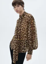 Blusa de tejido fluido con estampado animal print, lazo en el cuello, escote de pico, manga larga murciélago y cierre delantero con botones.